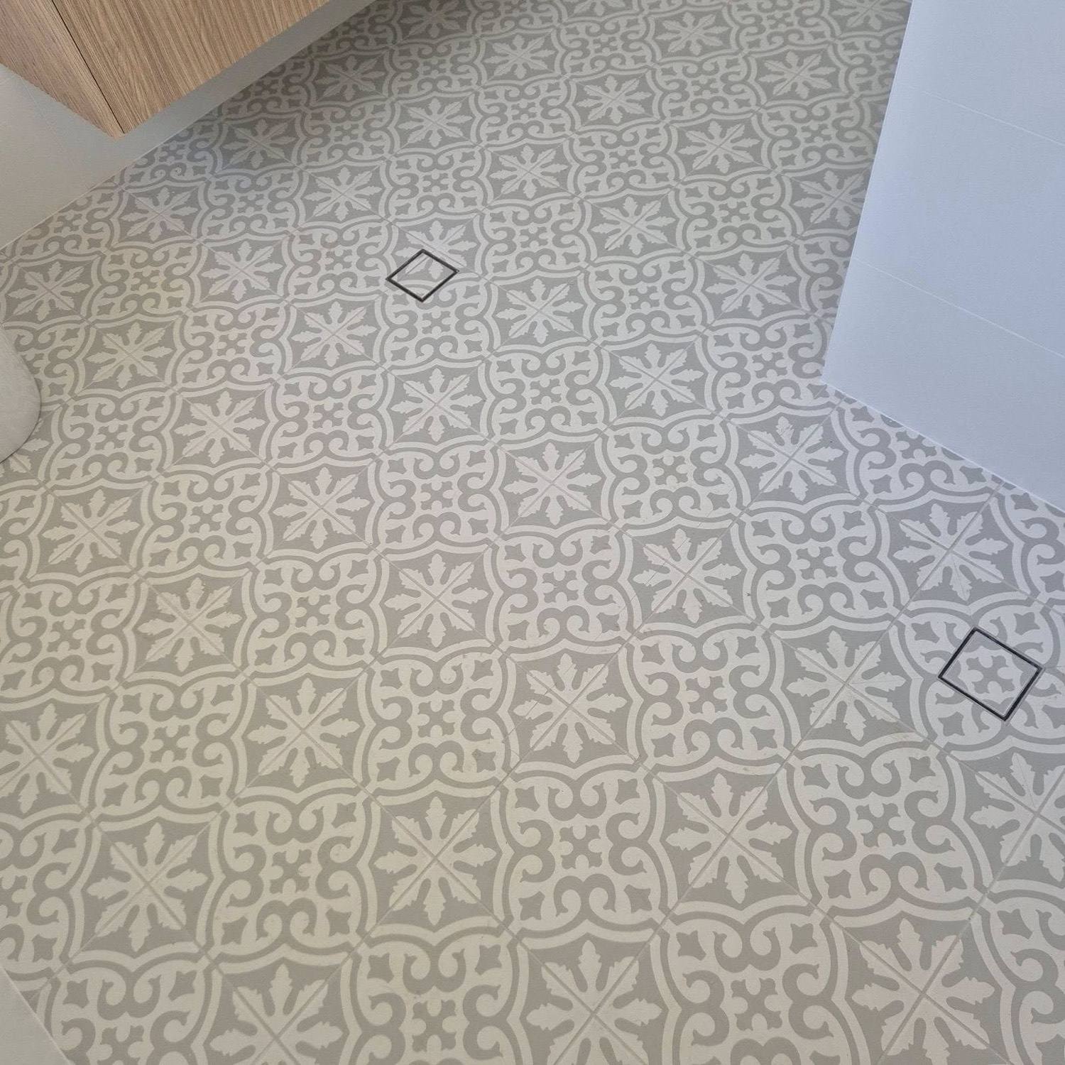 A floor laid in patterned encaustic-look tiles with a diamond feature