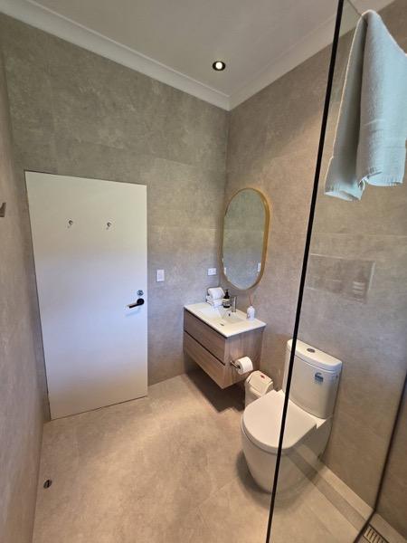 A rendered shower area with a mirror and vanity ready for tiling