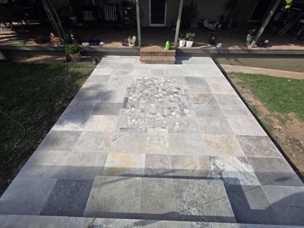 A stone path with a pebble inlay running across a lawn