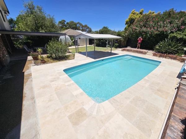 A pool and paved surround at a home on the edge of town